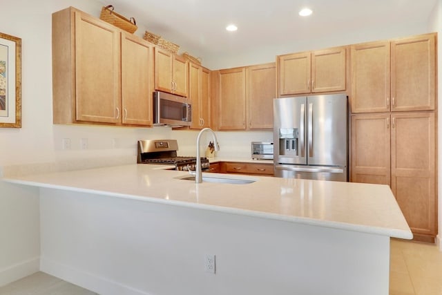 kitchen featuring light brown cabinets, a peninsula, recessed lighting, light countertops, and appliances with stainless steel finishes