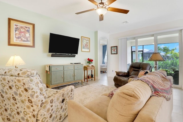 living area with light tile patterned floors, baseboards, and a ceiling fan