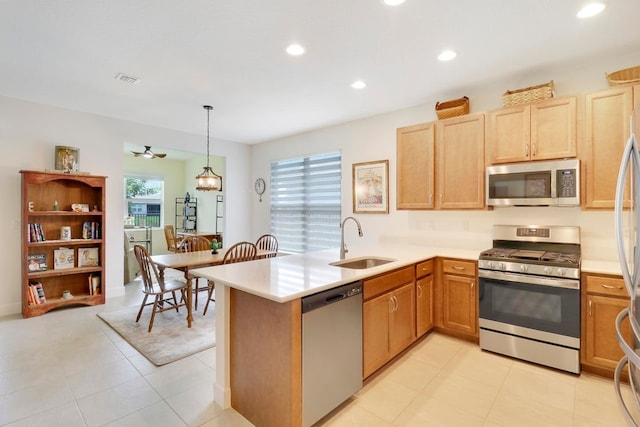 kitchen featuring a sink, recessed lighting, appliances with stainless steel finishes, a peninsula, and light countertops