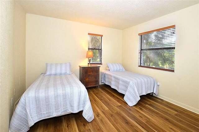 bedroom with dark hardwood / wood-style flooring and a textured ceiling