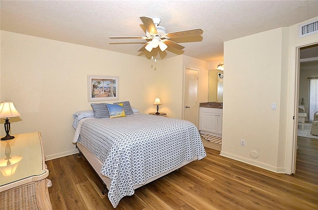 bedroom featuring a textured ceiling, dark hardwood / wood-style flooring, ensuite bath, and ceiling fan