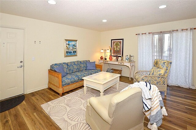 living room featuring a textured ceiling and dark hardwood / wood-style flooring