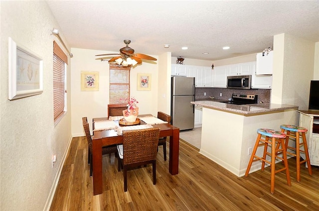 interior space featuring ceiling fan, a textured ceiling, and dark hardwood / wood-style flooring