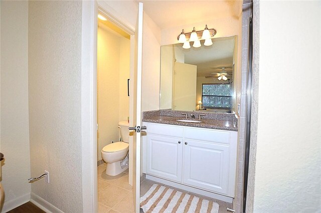 bathroom with tile patterned floors, vanity, toilet, and ceiling fan