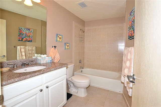 full bathroom with vanity, tile patterned flooring, tiled shower / bath combo, and toilet