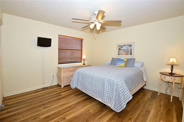 bedroom with dark hardwood / wood-style flooring and ceiling fan