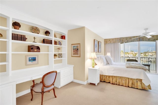 bedroom with built in desk, ceiling fan, light colored carpet, and access to exterior