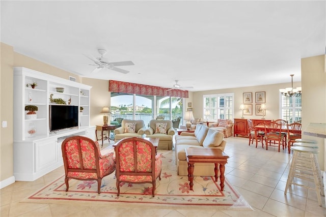 living room with ceiling fan with notable chandelier and light tile patterned floors