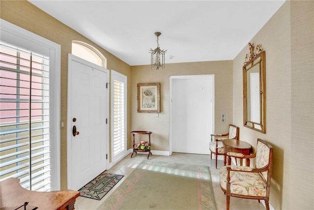 entryway featuring light tile patterned flooring, a notable chandelier, and a healthy amount of sunlight