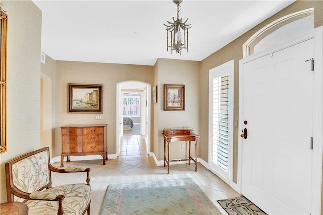 foyer with light tile patterned floors and a notable chandelier