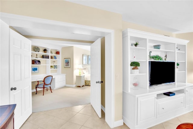 interior space featuring light carpet and built in desk