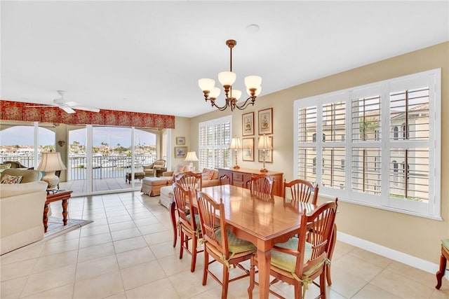 dining room featuring a healthy amount of sunlight, ceiling fan with notable chandelier, and light tile patterned floors