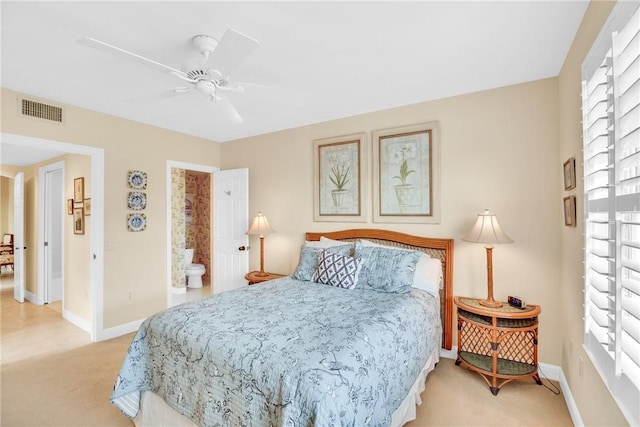 bedroom featuring light colored carpet, ensuite bath, and ceiling fan