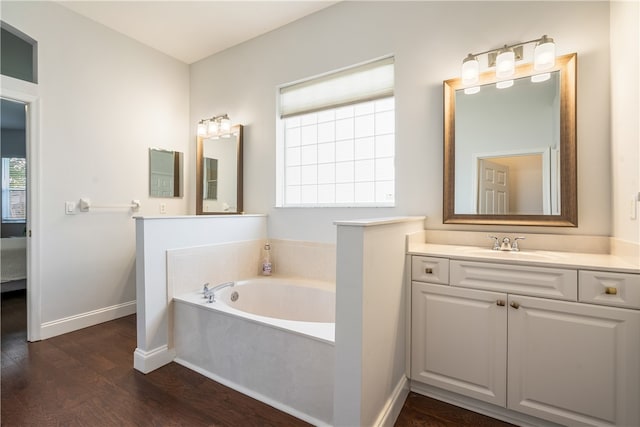 bathroom featuring a tub, hardwood / wood-style floors, and vanity