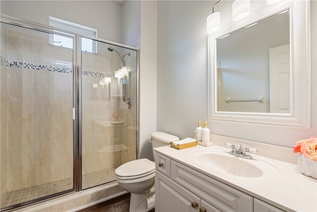 bathroom with vanity, toilet, and a shower with shower door