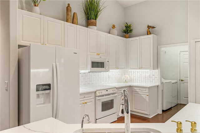 kitchen featuring decorative backsplash, dark hardwood / wood-style flooring, white appliances, washer and dryer, and white cabinets