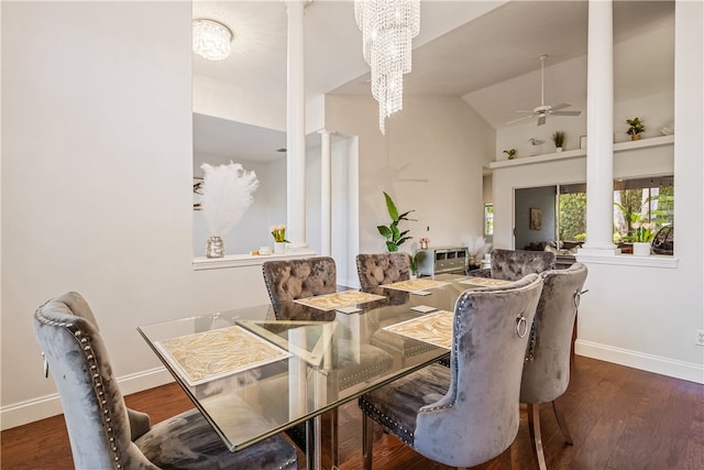 dining room featuring ceiling fan with notable chandelier, vaulted ceiling, dark hardwood / wood-style floors, and decorative columns