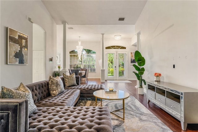 living room with decorative columns, french doors, and dark hardwood / wood-style floors