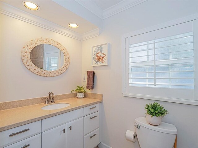 bathroom with vanity, toilet, and crown molding