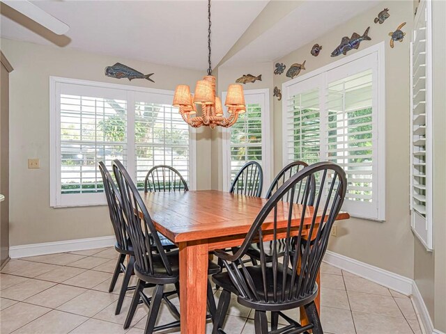 dining area featuring a wealth of natural light, light tile patterned floors, lofted ceiling, and an inviting chandelier