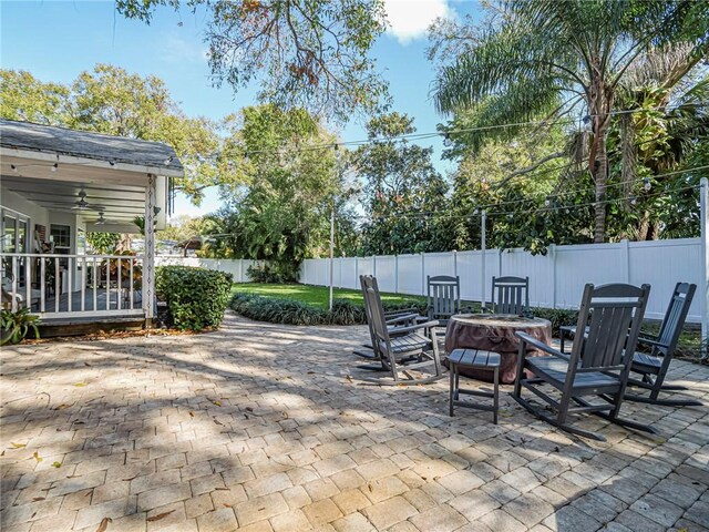 view of patio featuring ceiling fan and an outdoor fire pit