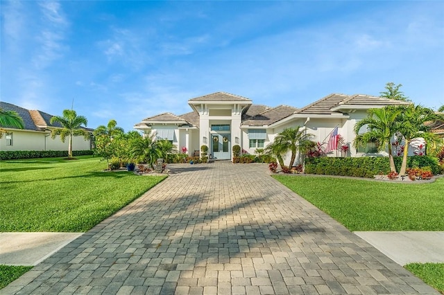 525 Stoney Brook Farm Ct, Vero Beach, FL 32968 - mediterranean / spanish-style house with decorative driveway, french doors, a front lawn, and stucco siding