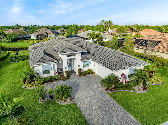525 Stoney Brook Farm Ct, Vero Beach, FL 32968 - view of front of home with decorative driveway, a tile roof, stucco siding, a residential view, and a front yard