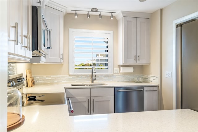 kitchen with decorative backsplash, white cabinetry, sink, and stainless steel appliances