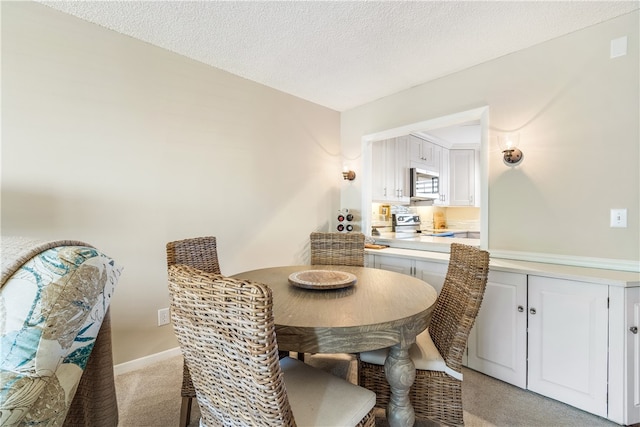 carpeted dining area featuring a textured ceiling