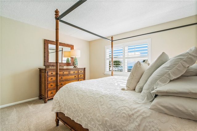 bedroom with a textured ceiling and light carpet