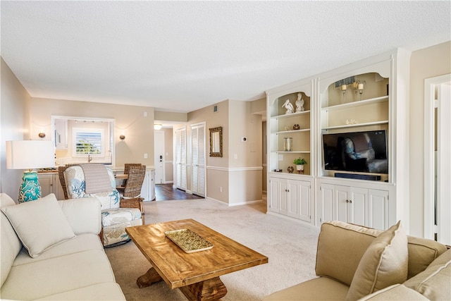 living room featuring a textured ceiling and light carpet