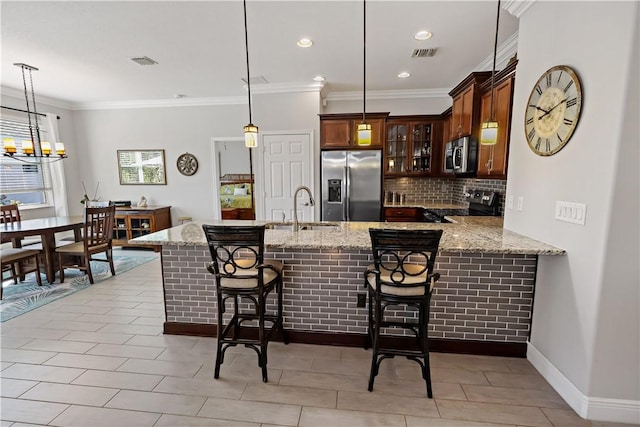 kitchen featuring backsplash, visible vents, appliances with stainless steel finishes, and a sink