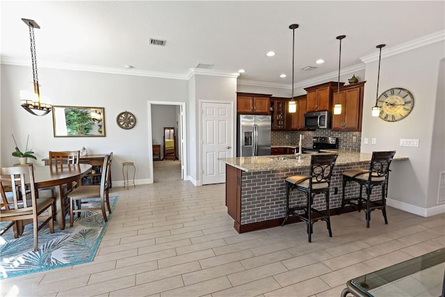 kitchen with light stone counters, visible vents, a peninsula, stainless steel appliances, and backsplash