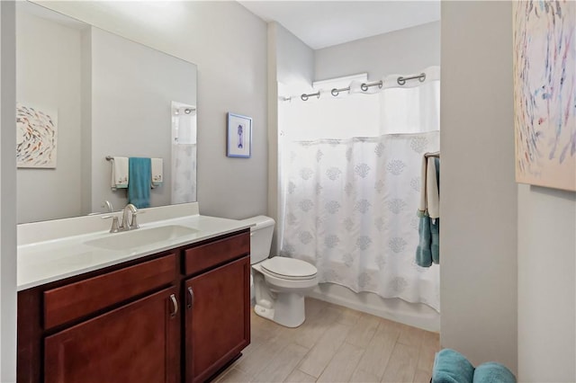 bathroom featuring vanity, toilet, wood finished floors, and shower / tub combo with curtain