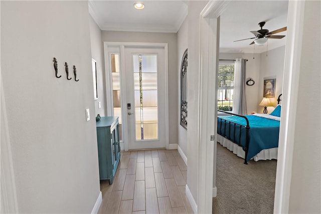 entryway with a ceiling fan, light wood-style floors, baseboards, and ornamental molding