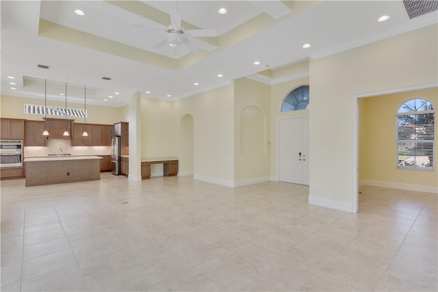 400 Sapphire Way SW, Vero Beach, FL 32968 - unfurnished living room with a raised ceiling, arched walkways, a ceiling fan, recessed lighting, and a towering ceiling