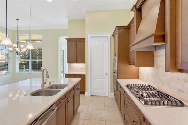 kitchen with sink, decorative light fixtures, ornamental molding, appliances with stainless steel finishes, and custom range hood