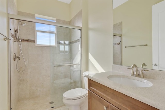 bathroom featuring vanity, a shower with shower door, and toilet