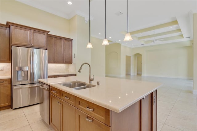 kitchen with pendant lighting, sink, light tile patterned floors, appliances with stainless steel finishes, and a center island with sink