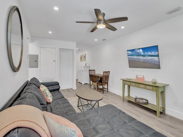 living room with electric panel, hardwood / wood-style flooring, and ceiling fan