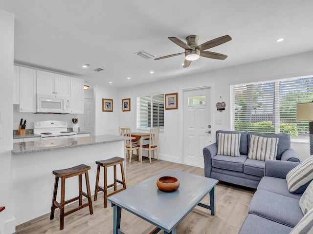 living room with light wood-type flooring and ceiling fan