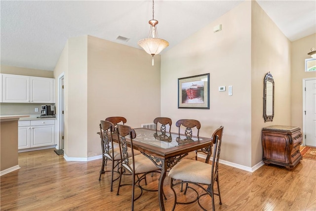 dining room featuring visible vents, baseboards, and light wood-style floors