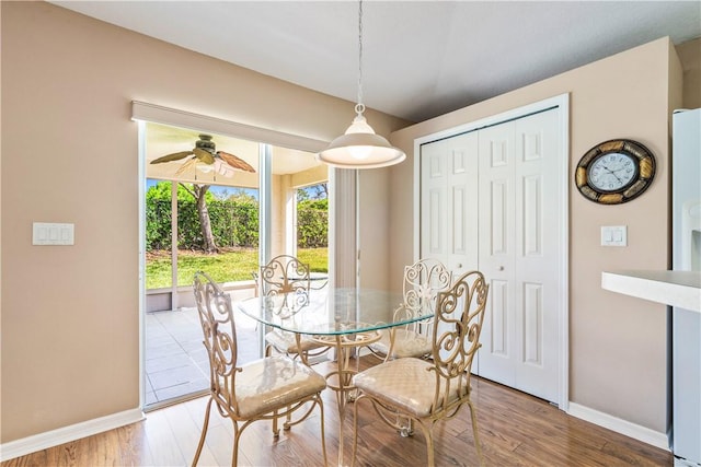 dining room with baseboards, light wood-style flooring, and a ceiling fan