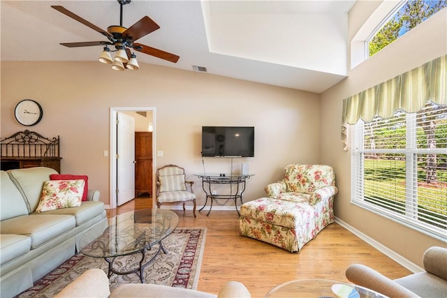 living room with a wealth of natural light, baseboards, light wood-style floors, and ceiling fan