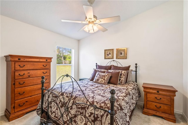 bedroom featuring vaulted ceiling, a ceiling fan, baseboards, and light carpet