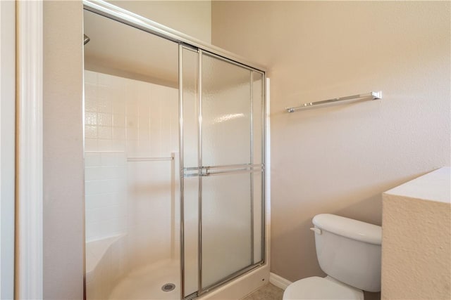 bathroom with toilet and a shower stall