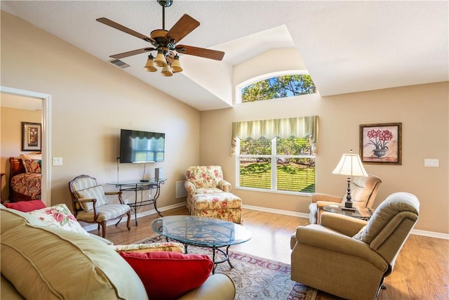 living room with vaulted ceiling, wood finished floors, baseboards, and ceiling fan