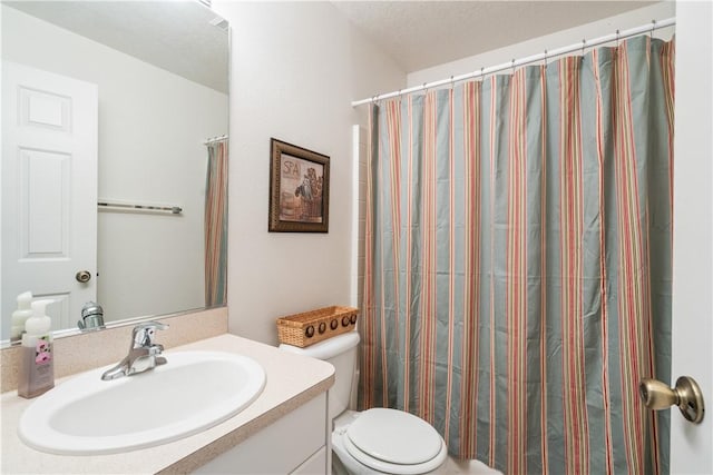 full bathroom featuring a shower with shower curtain, toilet, vanity, and a textured ceiling