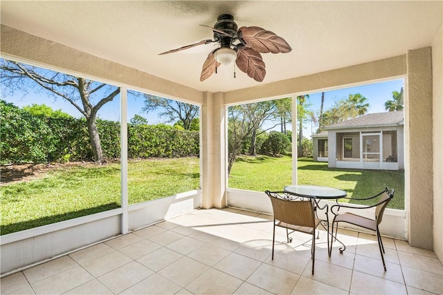 unfurnished sunroom featuring a wealth of natural light and a ceiling fan