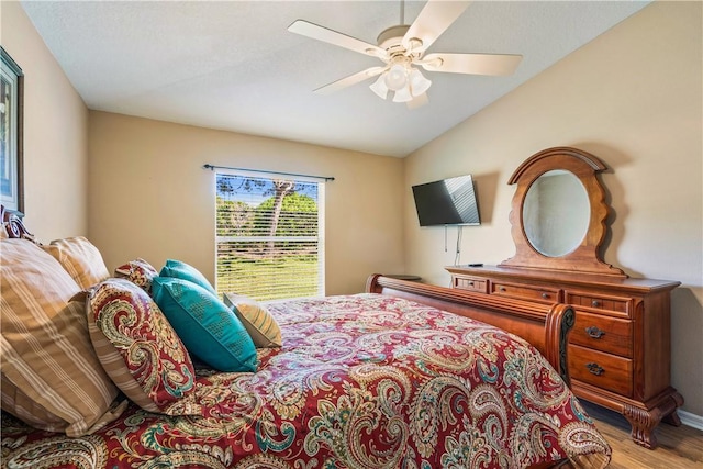 bedroom featuring baseboards, a ceiling fan, lofted ceiling, and wood finished floors